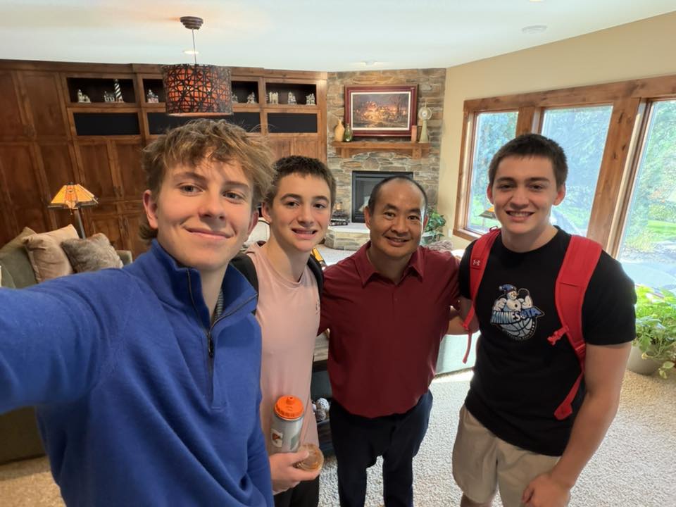 Group photo of four people posing together indoors.